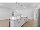 Well-lit kitchen with an island, stainless steel refrigerator, and white cabinetry at 104 Alta Vista Way, Davenport, FL 33837