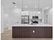 Bright kitchen features an island, stainless steel appliances, and white cabinets at 104 Alta Vista Way, Davenport, FL 33837