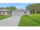 Charming single-story home featuring a two-car garage, grey exterior paint, and a well-manicured front lawn at 108 Alta Vista Way, Davenport, FL 33837