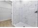 Walk-in shower featuring marble-look tile and black hardware; closet shelving in adjacent room at 108 Alta Vista Way, Davenport, FL 33837