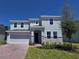 Charming two-story home featuring a two-car garage, stone accents, and well-manicured lawn at 1169 Happy Forest Loop, Deland, FL 32720