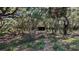 Heavily wooded lot with a small covered structure and a pile of debris at 1275 Arapaho Trl, Geneva, FL 32732