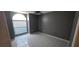 Cozy bedroom with tile flooring, large window, ceiling fan, and painted in a dark color at 129 Valentino Ct, Davenport, FL 33837