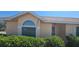 Charming single-story home exterior with a well-maintained lawn and an arched window at 129 Valentino Ct, Davenport, FL 33837