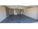 Spacious garage with painted walls and flooring and modern utility equipment at 129 Valentino Ct, Davenport, FL 33837
