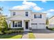 Charming two-story home boasting a well-manicured lawn, covered porch and two-car garage at 13242 Orange Isle Dr, Windermere, FL 34786