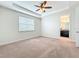 Bedroom boasts neutral carpet, a ceiling fan, and a view of the ensuite bathroom at 14014 Millington St, Orlando, FL 32832