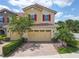 Charming townhome with red shutters, tile roof, two-car garage, and a brick driveway at 14014 Millington St, Orlando, FL 32832