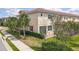 A side view of the townhome shows the surrounding landscaping, red shutter, and brick paver patio area at 14014 Millington St, Orlando, FL 32832