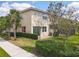 A side view of the townhome shows the surrounding landscaping, red shutter, and brick paver patio area at 14014 Millington St, Orlando, FL 32832