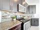 Close-up of the kitchen, showcasing granite countertops, backsplash and stainless steel appliances at 14014 Millington St, Orlando, FL 32832