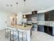 Modern kitchen featuring dark wood cabinets, granite countertops, stainless steel appliances, and a kitchen island at 14014 Millington St, Orlando, FL 32832