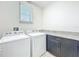 A functional laundry room includes a washer, dryer, counter and storage cabinets at 14014 Millington St, Orlando, FL 32832