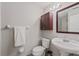 A half bathroom with vanity, toilet, and dark cabinets for storage at 145 Burns Ave, Longwood, FL 32750