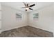 A minimal bedroom with wood plank flooring, ceiling fan, and two windows at 145 Burns Ave, Longwood, FL 32750