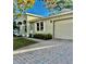 Beige home featuring an attached garage and beautiful brick paver driveway at 145 Burns Ave, Longwood, FL 32750