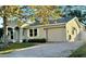 Beige home featuring an attached garage and beautiful brick paver driveway at 145 Burns Ave, Longwood, FL 32750