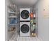 Organized laundry room features a stackable washer and dryer and shelving units at 145 Burns Ave, Longwood, FL 32750
