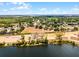Expansive aerial view showcasing a lakefront community with scattered homes and natural green spaces at 14723 Peppermill Trl, Clermont, FL 34711