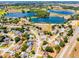 Panoramic aerial view showcasing houses nestled amidst lush trees and scenic lakes in a vibrant community at 14723 Peppermill Trl, Clermont, FL 34711