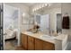 Well-lit bathroom featuring a double sink vanity and doorway view to Primary bedroom at 14723 Peppermill Trl, Clermont, FL 34711