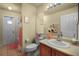 Charming bathroom with tiled floor, peach colored shower curtain and a decorative mirror at 14723 Peppermill Trl, Clermont, FL 34711