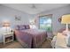 Comfortable bedroom with lavender bedding, a ceiling fan, and natural light at 14723 Peppermill Trl, Clermont, FL 34711