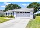 Charming single-story home with a long driveway and an attached two-car garage at 14723 Peppermill Trl, Clermont, FL 34711