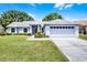 Charming single-story home with a well-maintained lawn and an attached two-car garage at 14723 Peppermill Trl, Clermont, FL 34711