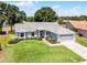 Charming single-story home with a well-maintained lawn and an attached two-car garage at 14723 Peppermill Trl, Clermont, FL 34711