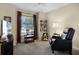 Cozy living room featuring a comfortable chair, soft carpet, and natural light from the window at 14723 Peppermill Trl, Clermont, FL 34711