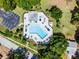 Aerial view of a community pool area, featuring lounge chairs and landscaping at 14723 Peppermill Trl, Clermont, FL 34711
