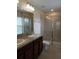 Bathroom featuring double sinks, granite countertops, and tiled shower at 14867 Driftwater Dr, Winter Garden, FL 34787