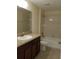 Bathroom featuring single sink, granite countertops, and tub with shower at 14867 Driftwater Dr, Winter Garden, FL 34787