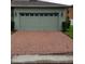 A large two car garage with a brick driveway offers ample parking and curb appeal at 14867 Driftwater Dr, Winter Garden, FL 34787