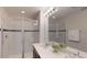 A modern bathroom features dual sinks, a large mirror, and glass shower doors at 1569 Carey Palm Cir, Kissimmee, FL 34747