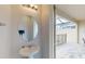 Powder room featuring a pedestal sink with a round mirror and access to the pool area at 1569 Carey Palm Cir, Kissimmee, FL 34747