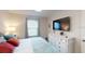 This bedroom features a TV, a white dresser, and a comfortable bed with accent pillows at 1569 Carey Palm Cir, Kissimmee, FL 34747
