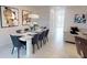 Dining room with large table and chairs adjacent to the living room, all boasting a contemporary design at 1569 Carey Palm Cir, Kissimmee, FL 34747