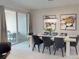 Dining room with a modern light fixture, table and chairs, and a view of the outdoor patio at 1569 Carey Palm Cir, Kissimmee, FL 34747