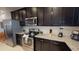 Close-up view of the kitchen with stainless steel appliances, granite countertops, and dark cabinetry at 1569 Carey Palm Cir, Kissimmee, FL 34747
