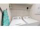 Laundry room with washer, dryer, shelves, and an ironing board at 1569 Carey Palm Cir, Kissimmee, FL 34747