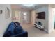 Neutral living room with plush blue sofa and wall-mounted television, carpeted floors and white trim at 1569 Carey Palm Cir, Kissimmee, FL 34747