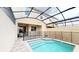 Swimming pool under a screened enclosure with a safety fence at 1569 Carey Palm Cir, Kissimmee, FL 34747