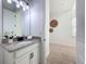 Well-lit bathroom featuring a granite countertop, white cabinets, and a decorative mirror enhancing the space at 15727 Vetta Dr, Montverde, FL 34756
