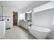 Bright bathroom featuring a soaking tub, double vanity with granite countertops, and modern fixtures at 15727 Vetta Dr, Montverde, FL 34756
