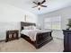 Elegant bedroom featuring a dark wood bed frame, neutral bedding, and a window with natural light at 15727 Vetta Dr, Montverde, FL 34756