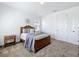 Cozy bedroom with a wooden bed frame, neutral-toned bedding, carpet flooring and a sunburst mirror at 15727 Vetta Dr, Montverde, FL 34756