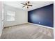 Bedroom featuring dark accent wall, neutral carpet, and a bright window at 15727 Vetta Dr, Montverde, FL 34756