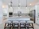 Kitchen island featuring granite countertops, pendant lighting, and barstool seating, ideal for casual dining at 15727 Vetta Dr, Montverde, FL 34756